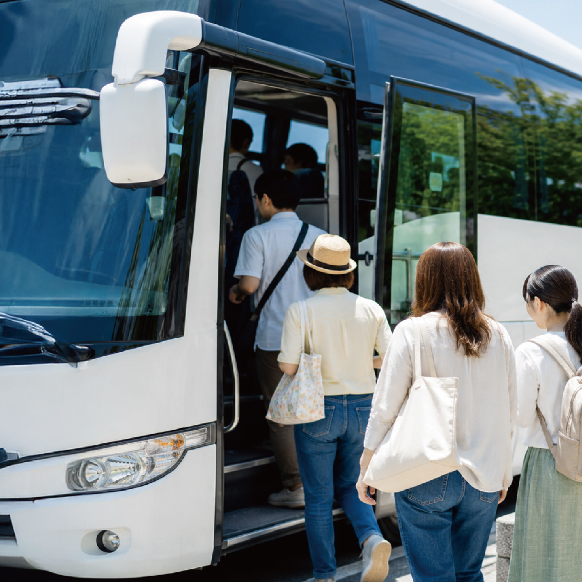 貸切バスに乗り込む団体旅行の参加者