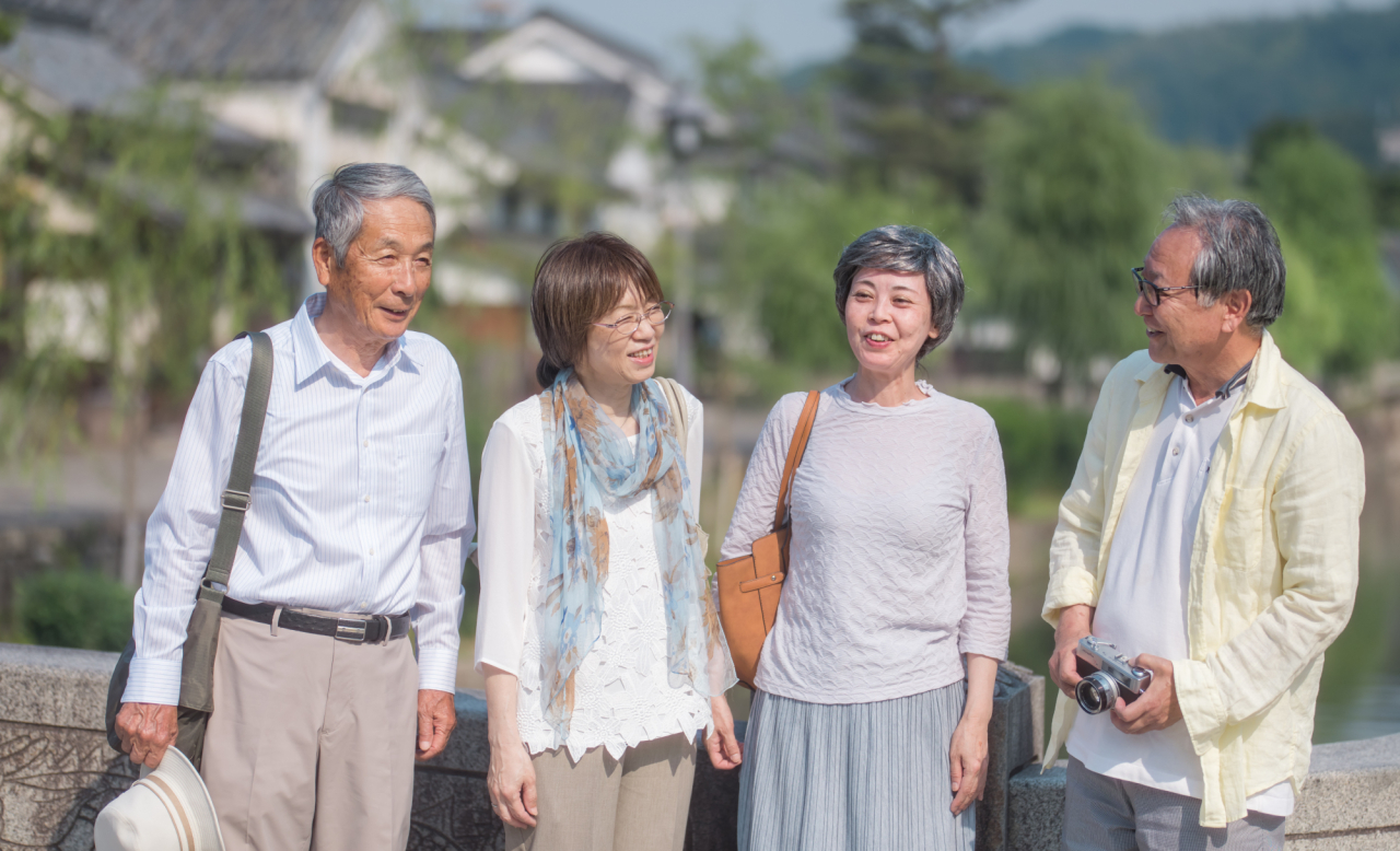 観光地を歩きながら会話を楽しむシニア世代の旅行者