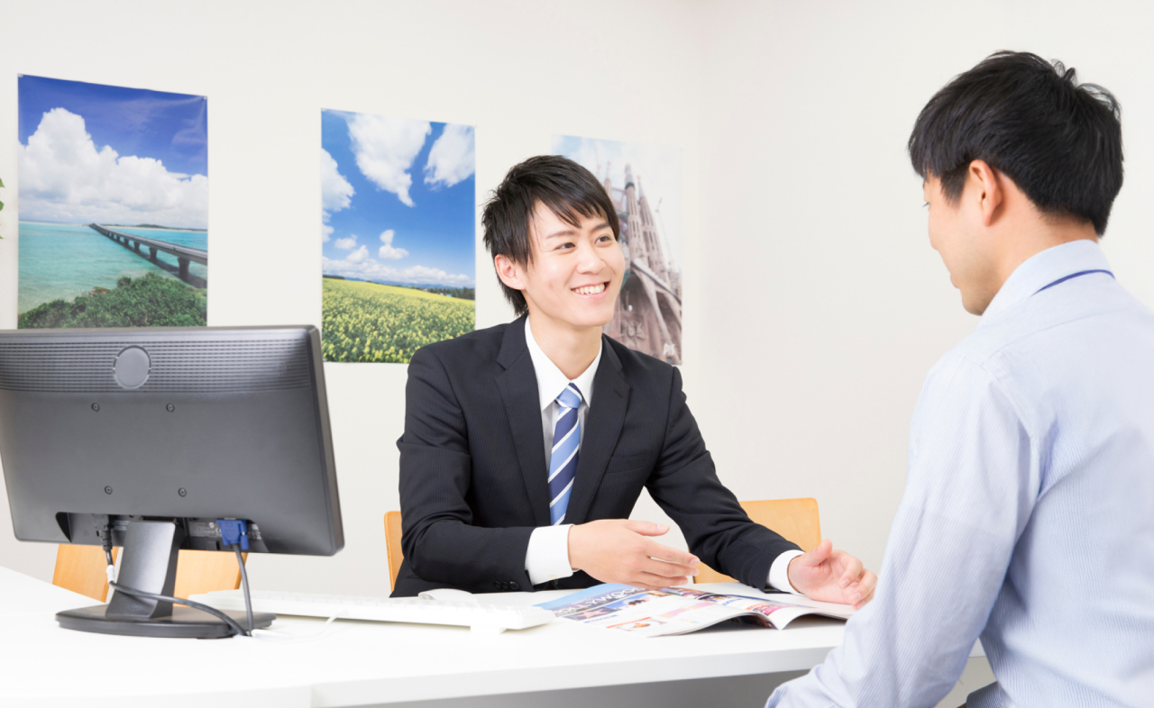 旅行について相談する参加者と旅行スタッフ