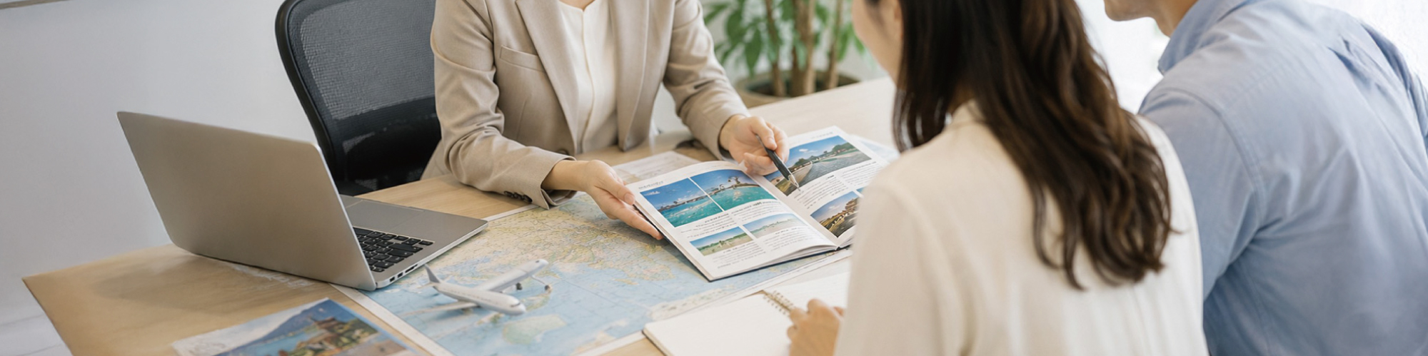 旅行スタッフと参加者が地図や旅行パンフレットを見ながら旅行を相談している様子