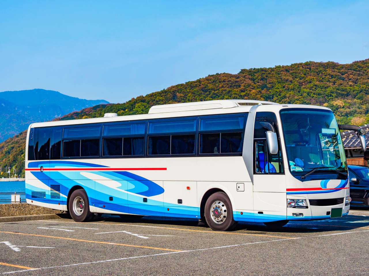 山を背景に駐車された大型の貸切バス