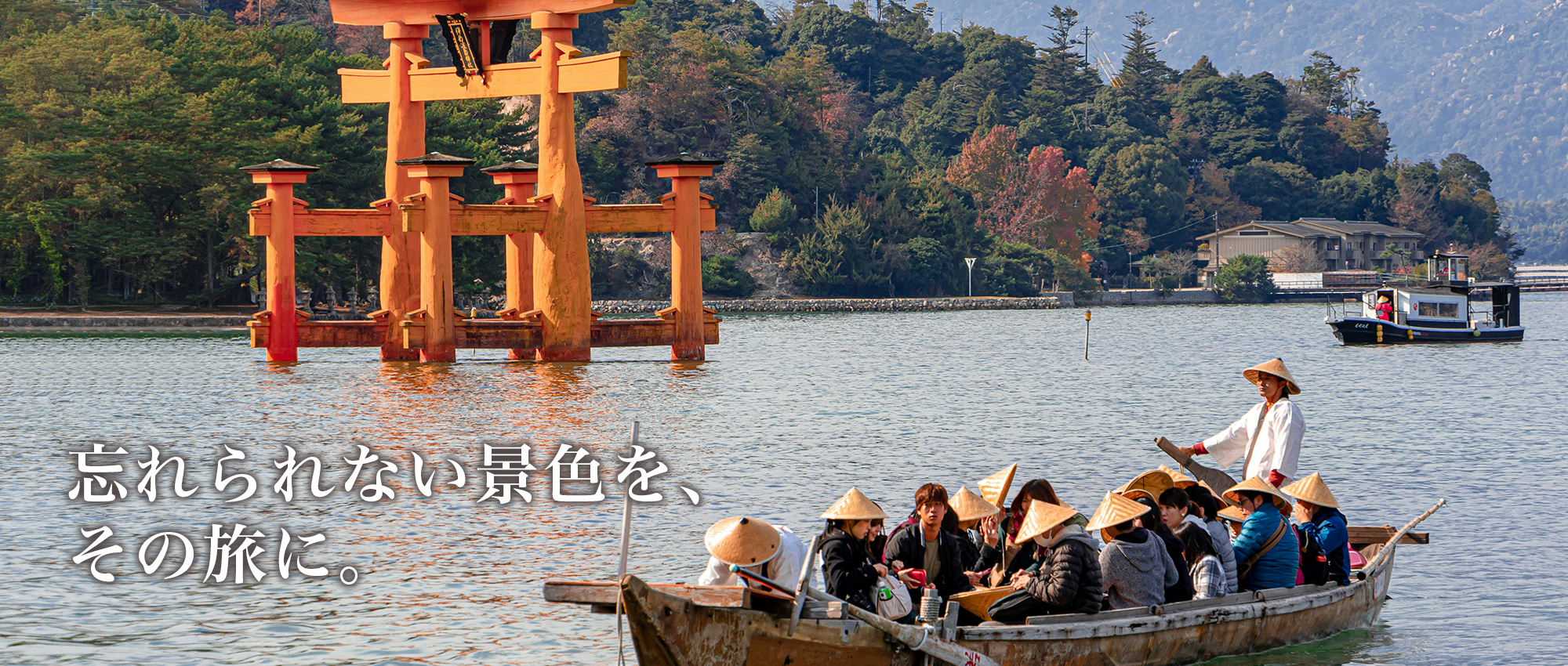 宮島の大鳥居を眺めながら船で観光する旅行者