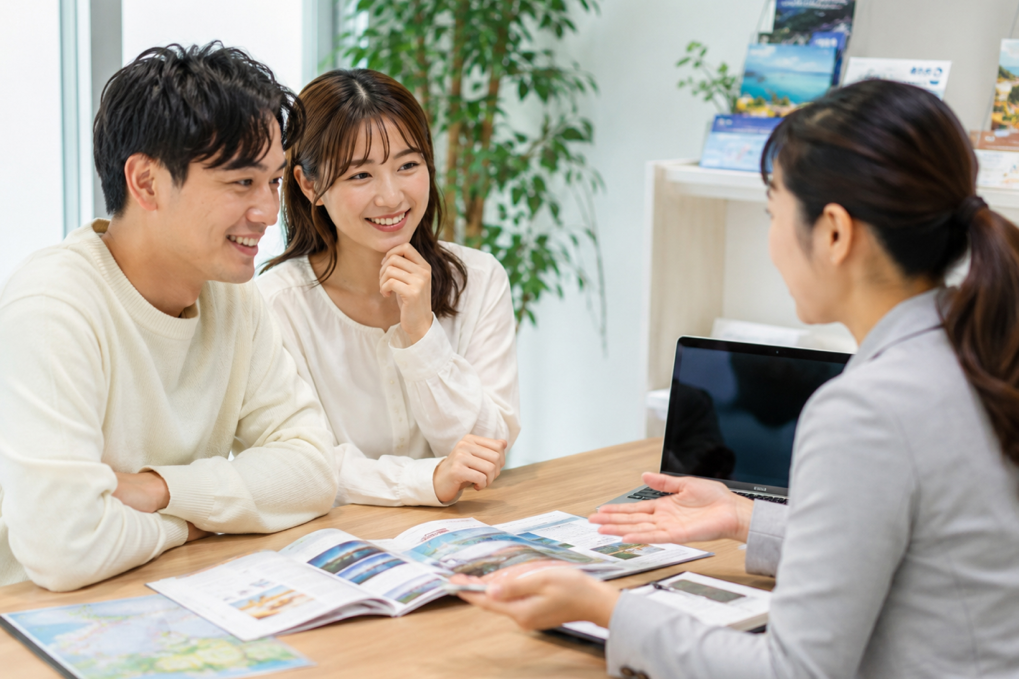 旅行スタッフと参加者が旅行パンフレットを見ながら旅行を相談している様子